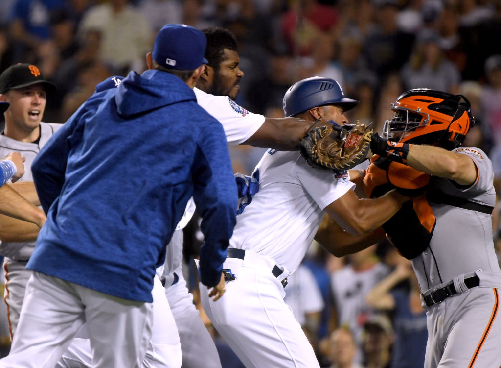 LOS ANGELES, CA - AUGUST 14:  Yasiel Puig #66 of the Los Angeles Dodgers and Nick Hundley #5 of the San Francisco Giants fight as first base coach George Lombard #29 comes between the two during the seventh inning at Dodger Stadium on August 14, 2018 in Los Angeles, California.  Both players would be ejected from the game.  (Photo by Harry How/Getty Images)
