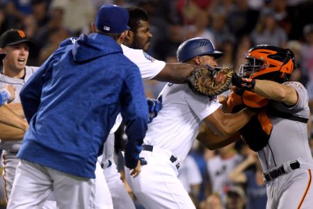 LOS ANGELES, CA - AUGUST 14:  Yasiel Puig #66 of the Los Angeles Dodgers and Nick Hundley #5 of the San Francisco Giants fight as first base coach George Lombard #29 comes between the two during the seventh inning at Dodger Stadium on August 14, 2018 in Los Angeles, California.  Both players would be ejected from the game.  (Photo by Harry How/Getty Images)