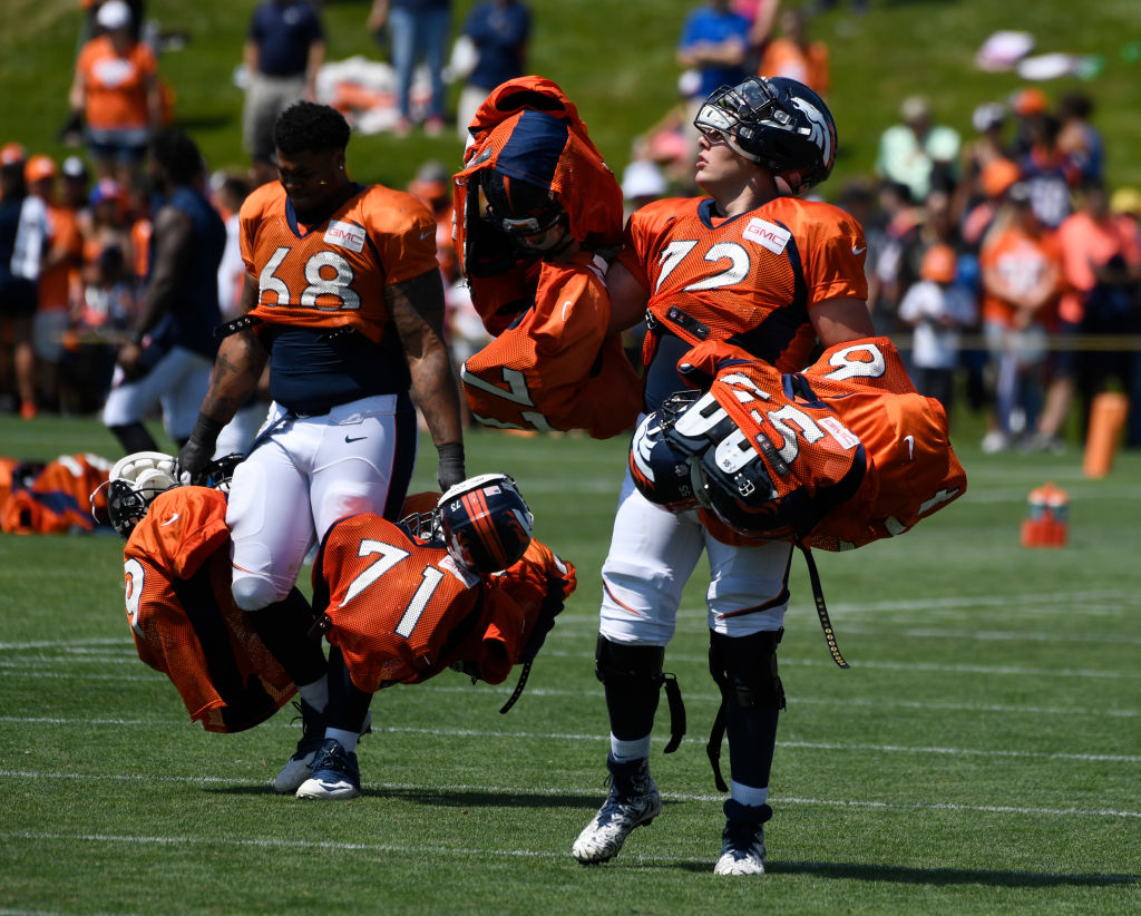 ENGLEWOOD, CO - AUGUST 02: Denver Broncos rookie offensive tackle Elijah Wilkinson #68 and rookie offensive tackle Garett Bolles #72 pay their dues by carrying veteran's pads and helmets into the locker room after practice at Dove Valley August 02, 2017. (Photo by Andy Cross/The Denver Post via Getty Images)
