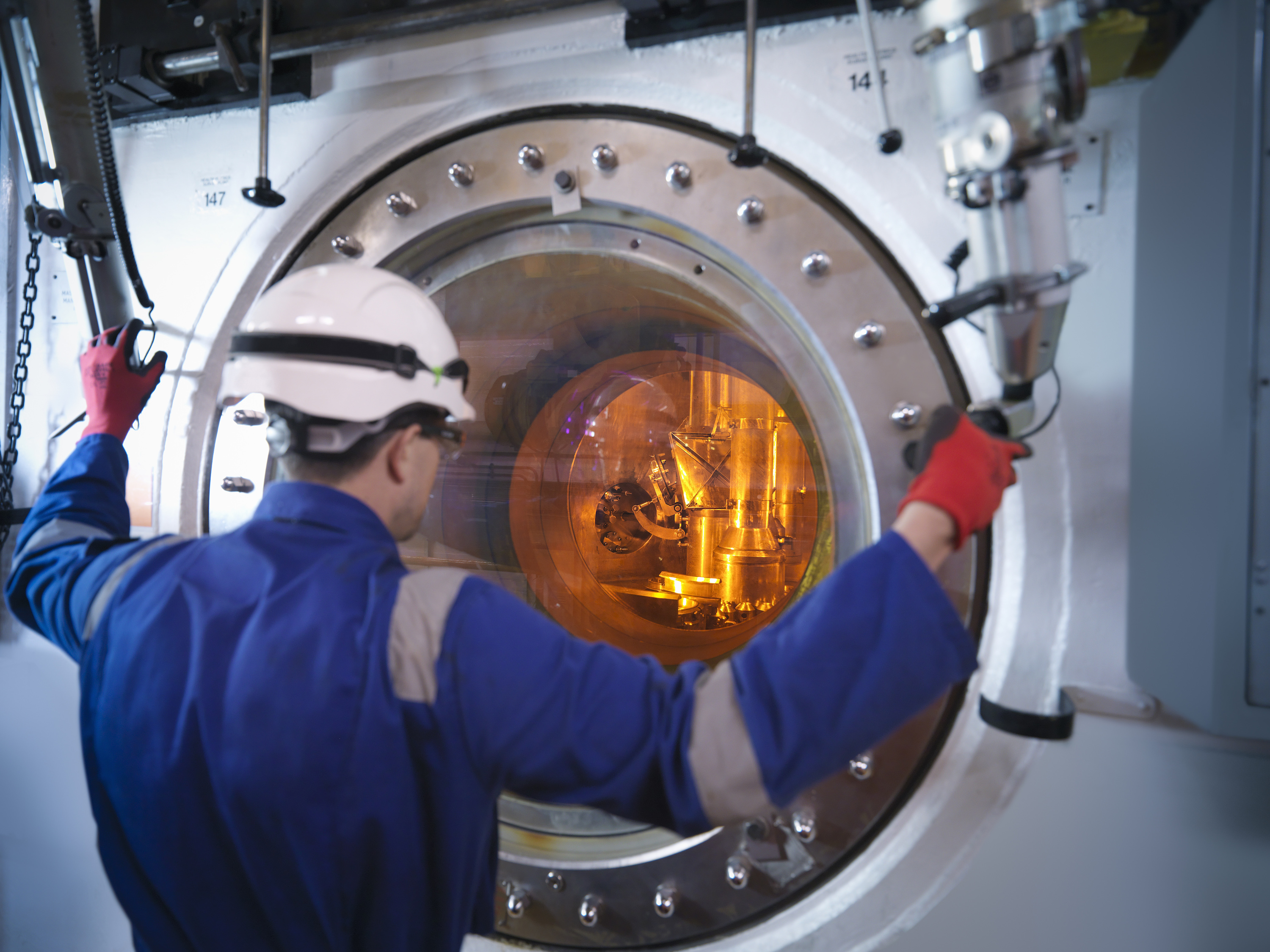 Engineer with fuel rod handling machine in nuclear power station