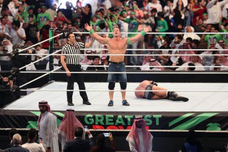 John Cena (C) celebrates defeating Triple H (R) during the World Wrestling Entertainment (WWE) Greatest Royal Rumble event in the Saudi coastal city of Jeddah on April 27, 2018. (Photo by STRINGER / AFP) 
