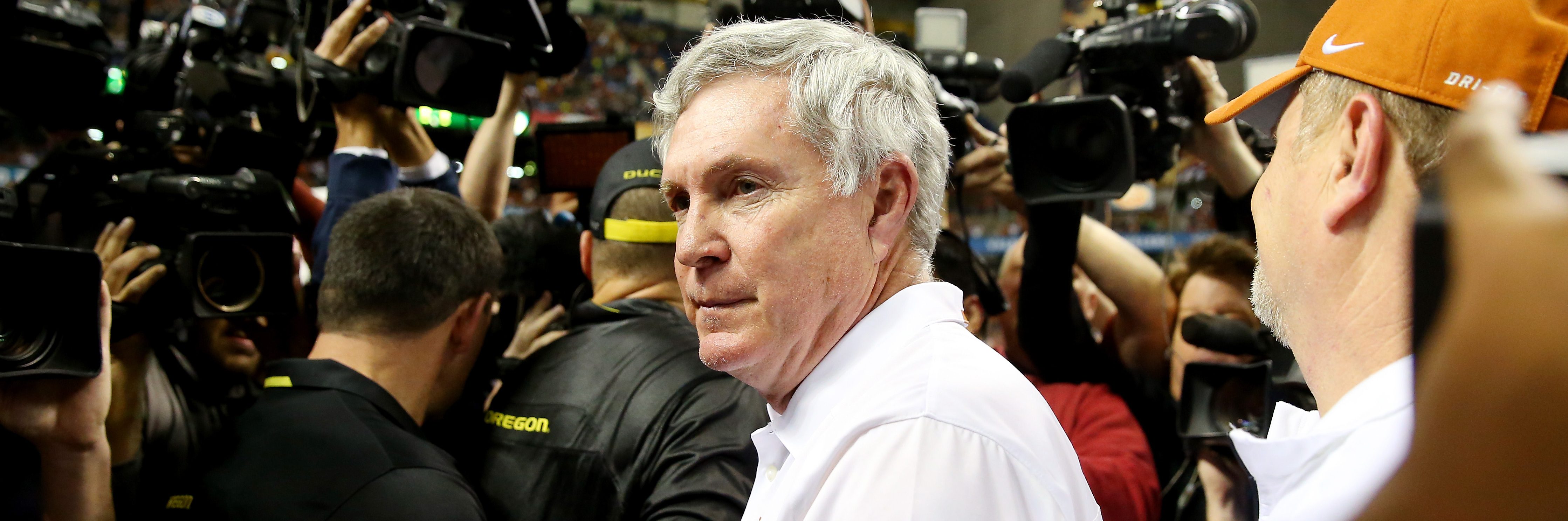 Head coach Mack Brown of the Texas Longhorns meets head coach Mark Helfrich of the Oregon Ducks on the field after the Valero Alamo Bowl at the Alamodome on December 30, 2013 in San Antonio, Texas. The Oregon Ducks defeated the Texas Longhorns 30-7.  (Photo by Ronald Martinez/Getty Images)