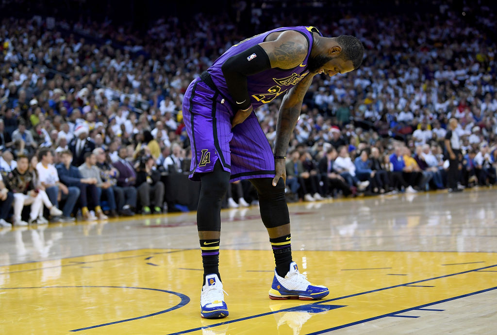 OAKLAND, CA - DECEMBER 25:  LeBron James #23 of the Los Angeles Lakers leans over in pain after he was hurt against the Golden State Warriors during the second half of their NBA Basketball game at ORACLE Arena on December 25, 2018 in Oakland, California. (Photo by Thearon W. Henderson/Getty Images)