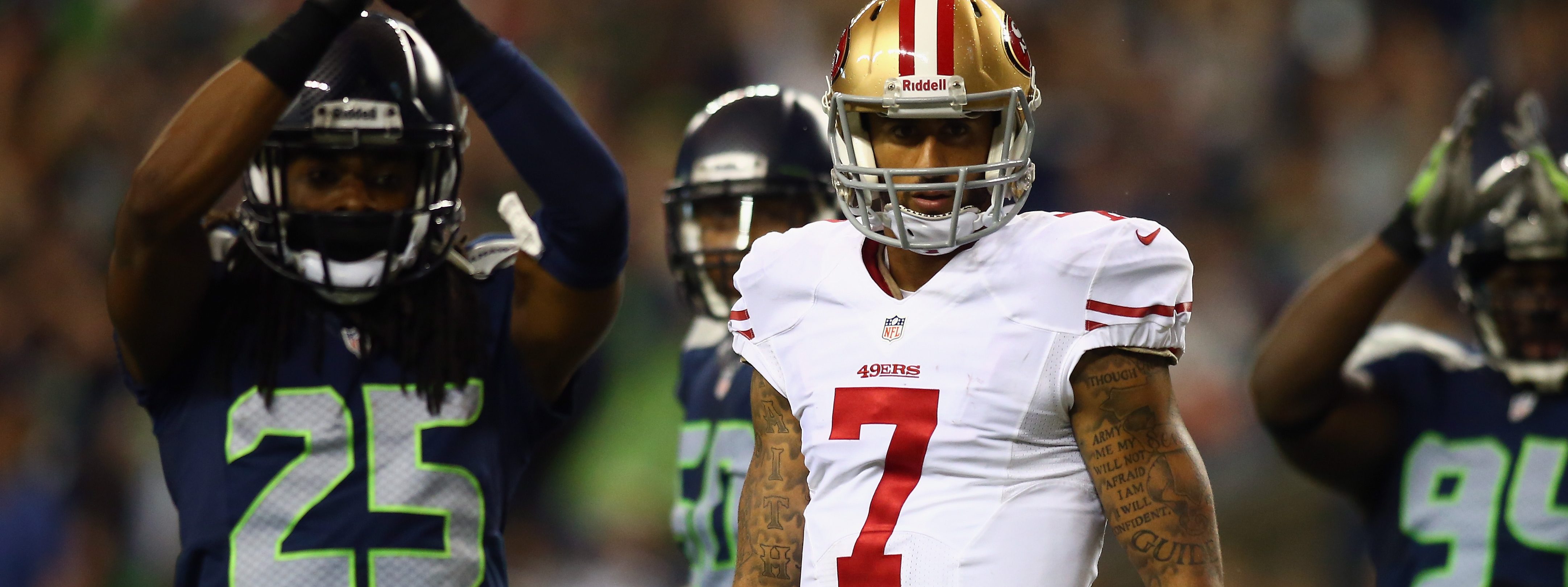 Colin Kaepernick #7 of the San Francisco 49ers looks on as Richard Sherman #25 and D'Anthony Smith #94 of the Seattle Seahawks celebrate a saftey during their game at Qwest Field on September 15, 2013 in Seattle, Washington.  (Photo by Jonathan Ferrey/Getty Images)