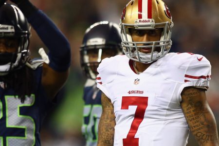 Colin Kaepernick #7 of the San Francisco 49ers looks on as Richard Sherman #25 and D'Anthony Smith #94 of the Seattle Seahawks celebrate a saftey during their game at Qwest Field on September 15, 2013 in Seattle, Washington.  (Photo by Jonathan Ferrey/Getty Images)