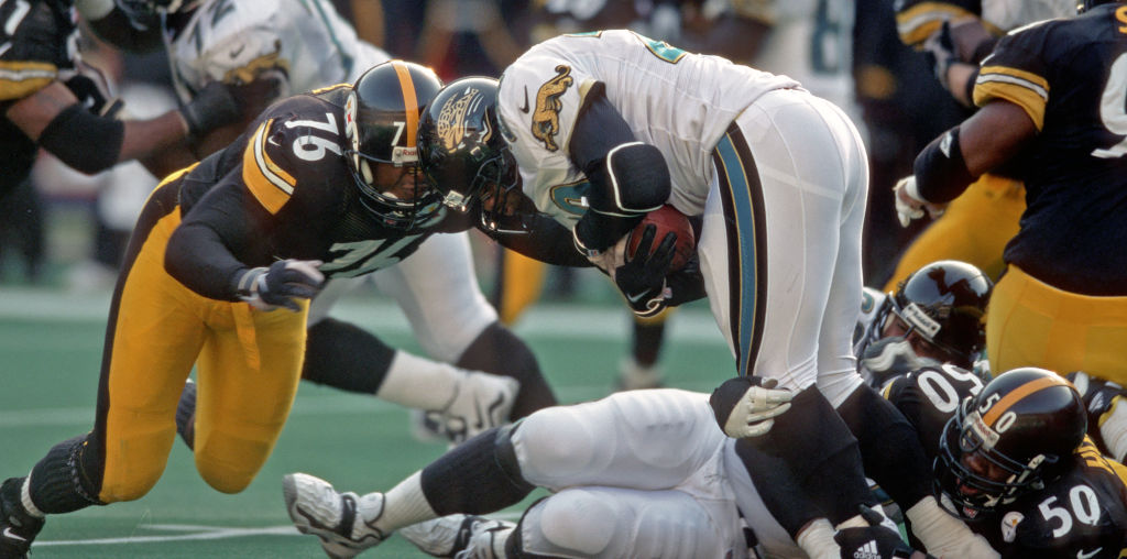 PITTSBURGH, PA - NOVEMBER 22:  Defensive lineman Kevin Henry #76 and linebacker Earl Holmes #50 of the Pittsburgh Steelers tackle running back Fred Taylor #28 of the Jacksonville Jaguars during a game at Three Rivers Stadium on November 22, 1998 in Pittsburgh, Pennsylvania.  The Steelers defeated the Jaguars 20-15.  (Photo by George Gojkovich/Getty Images)