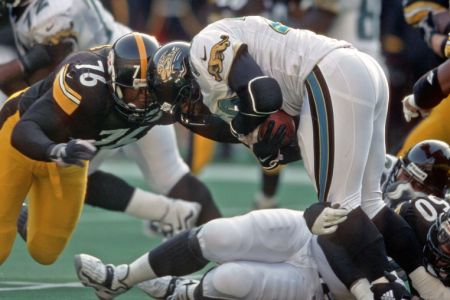 PITTSBURGH, PA - NOVEMBER 22:  Defensive lineman Kevin Henry #76 and linebacker Earl Holmes #50 of the Pittsburgh Steelers tackle running back Fred Taylor #28 of the Jacksonville Jaguars during a game at Three Rivers Stadium on November 22, 1998 in Pittsburgh, Pennsylvania.  The Steelers defeated the Jaguars 20-15.  (Photo by George Gojkovich/Getty Images)