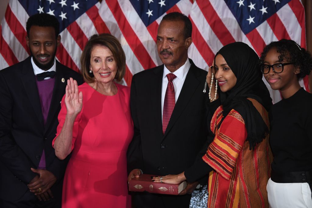 US House Representative Ilhan Omar (2nd-R), D-MN, with her hand on the Quran, participates in a ceremonial swearing-in with Speaker of the House Nancy Pelosi (2nd-L), D-CA,  during the start of the 116th Congress at the US Capitol in Washington, DC, January 3, 2019. (Photo by SAUL LOEB / AFP)        (Photo credit should read SAUL LOEB/AFP/Getty Images)