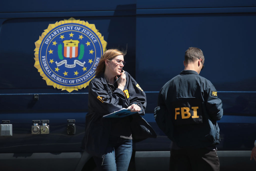 SUNSET VALLEY, TX - MARCH 20:  FBI agents collect evidence at a FedEx Office facility following an explosion at a nearby sorting center on March 20, 2018 in Sunset Valley, Texas. A package, reported to have been shipped from this store, exploded while being transported on a conveyor shortly after midnight this morning at the sorting facility in Schertz, Texas causing minor injuries to one person. The explosion is believed to be related to several recent package bombs that have been detonated in Austin, Texas.  (Photo by Scott Olson/Getty Images)