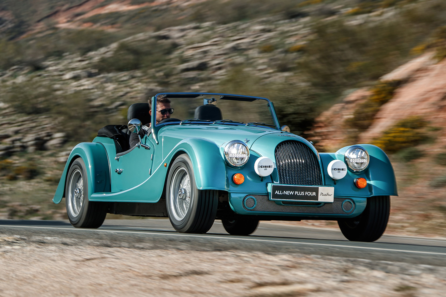 Blue roadster driving in the country