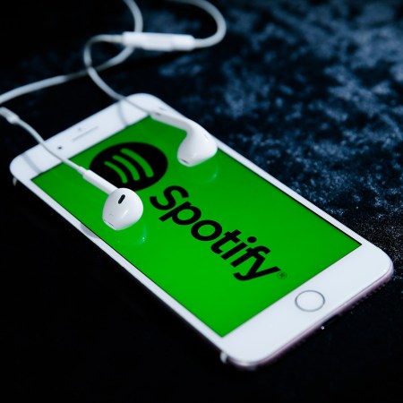 iPhone smartphone with headphones playing Spotify