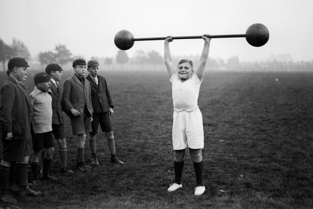 A young fellow lifting a barbell in the 1930s. Is he "stunting" his growth? 
