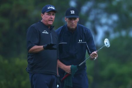 Phil Mickelson reads a putt for NFL player Tom Brady during The Match. (Mike Ehrmann/Getty for The Match)