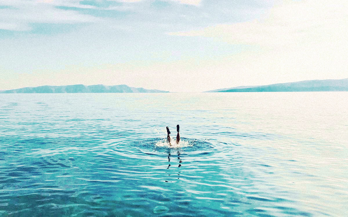 A man swimming in a pond.