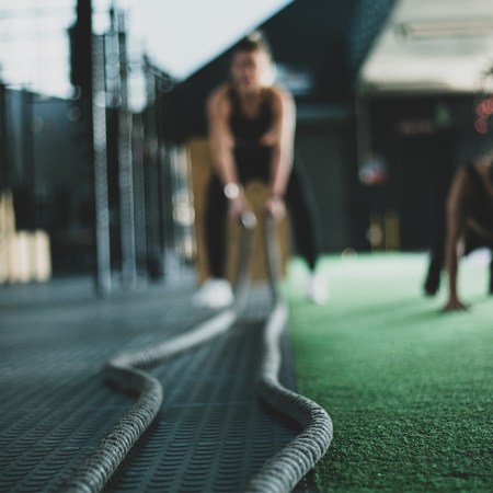Athlete in the gym holding battle ropes