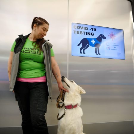 The coronavirus sniffer dog named E.T. receives a cuddle from the trainer Anette Kare at the Helsinki airport in Vantaa, Finland, where he is trained to detect the COVID-19 from the arriving passengers, on September 22, 2020