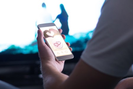 person holding a phone open to a dating apps