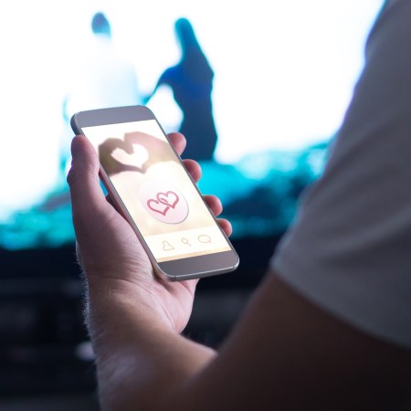 person holding a phone open to a dating apps