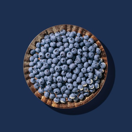 A high angle view of a bowl of blueberries, one of the best foods you can eat to beat morning anxiety