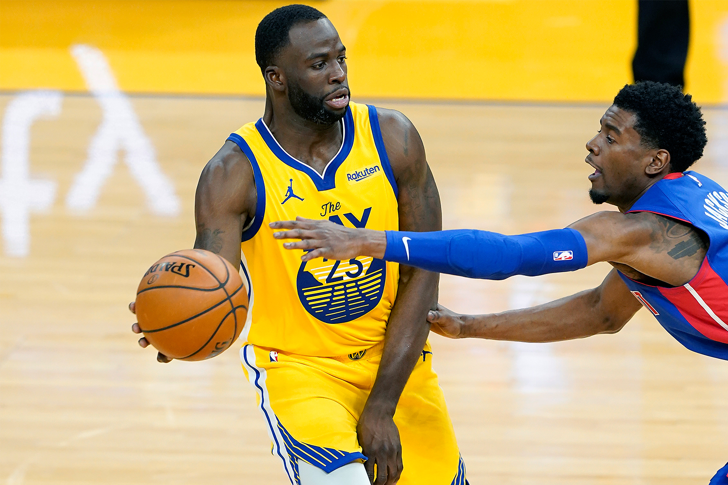 Draymond Green looks to pass the ball while being defended by Josh Jackson.  
