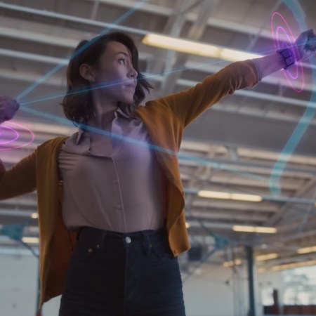 A woman shooting a virtual bow and arrow using a Facebook wrist wearable