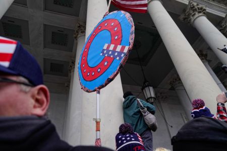 Someone holding up a Q sign