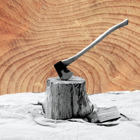 A black and white photo of an axe sticking in a wood stump with a wood-grain background