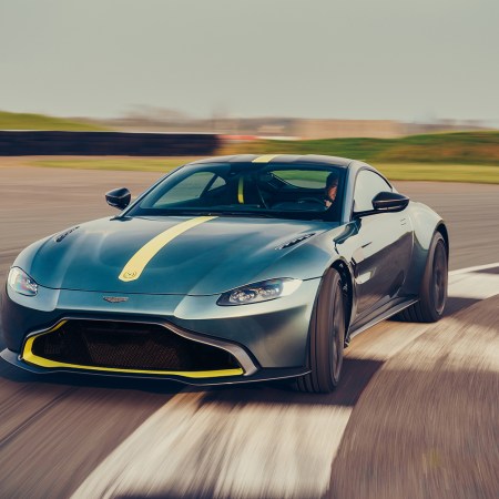 A green and yellow Aston Martin Vantage AMR speeding around a track