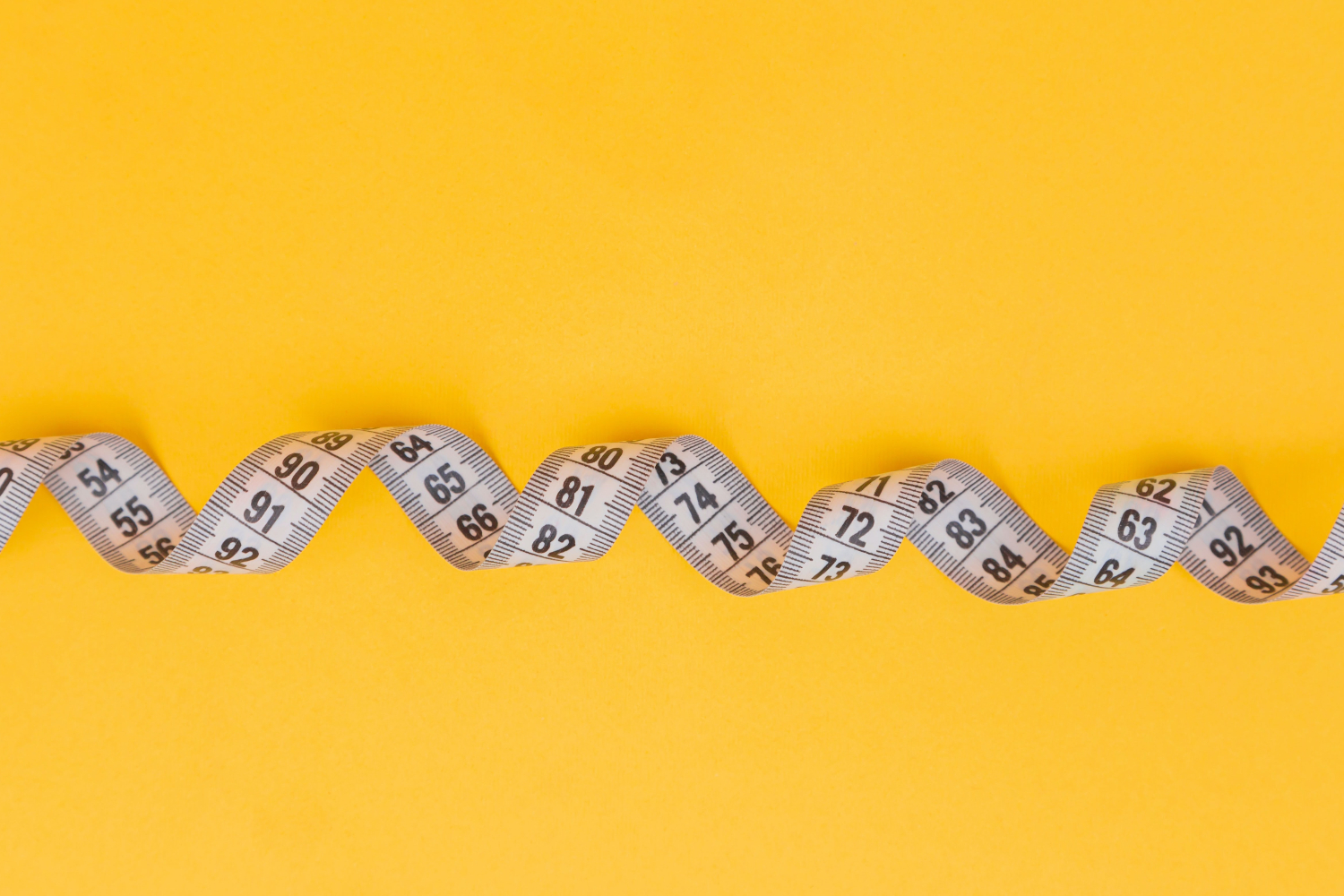measuring tape on yellow background