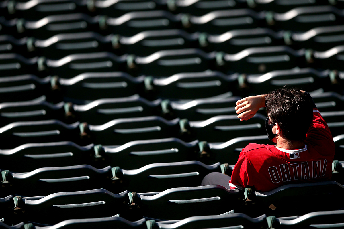 Fans lounging around a somewhat empty bleachers section at a baseball game.
