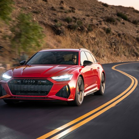 A red 2021 Audi RS 6 Avant driving down a coastal highway. We took the high-powered station wagon for a test drive.
