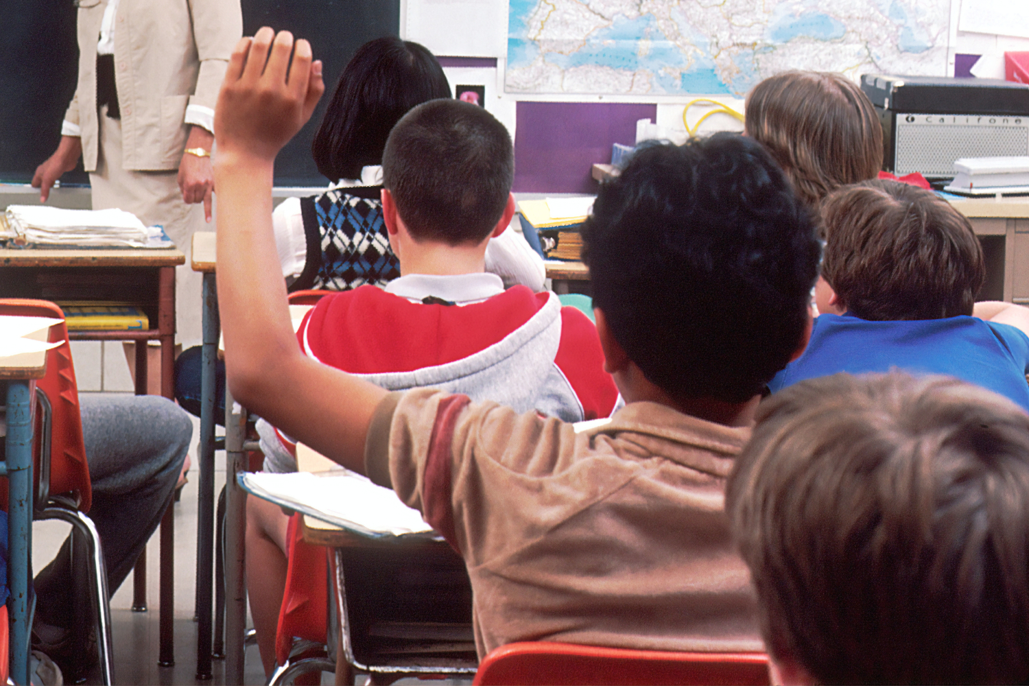 Child raises hand in classroom