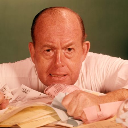 1960s ANGRY MAN BUSINESSMAN DESK FULL OF BILLS PAPER WORK OFFICE STRESS FRUSTRATION