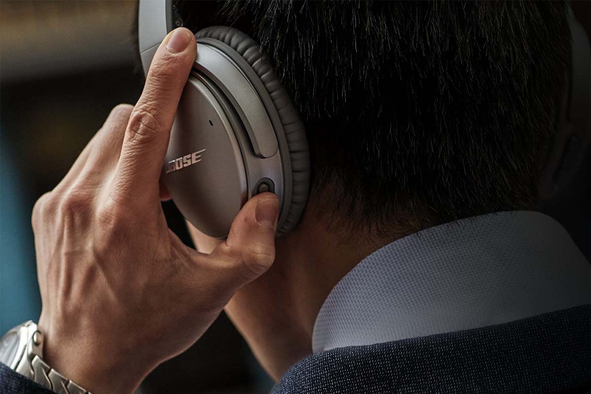 A man adjusting the controls on the Bose QuietComfort 35 II headphones