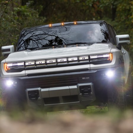The GMC Hummer EV supertruck, a new electric pickup truck, driving through the dirt