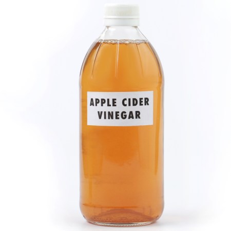 bottle of apple cider vinegar on white background