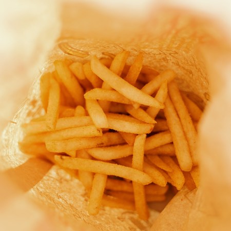 A photo of a a bunch of French fries at the bottom of a bag. Can fried food like this lead to migraines? A new study looks at the issue.