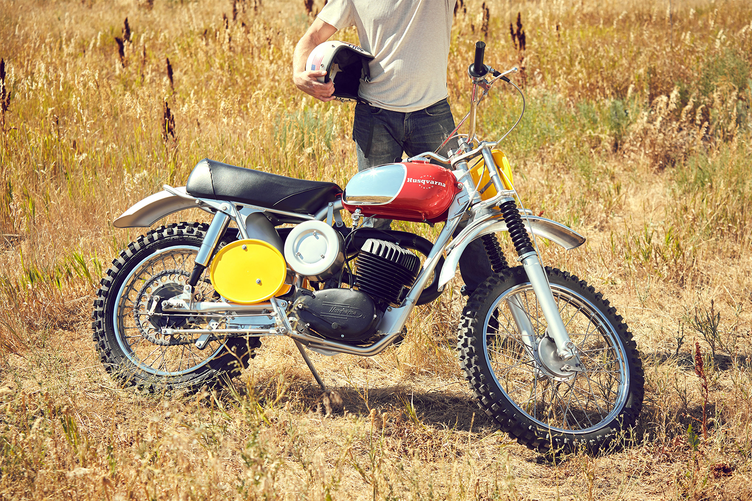 A man in a white T-shirt and blue jeans standing behind a 1968 Husqvarna Viking 360 that was owned by Steve McQueen. The motorcycle will sell at RM Sotheby's Monterey auction.