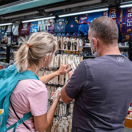 Two tourists are seen buying souvenirs at one of the traditional newsstands on La Rambla. The economic balance of the economic sectors that depend on tourism closed in August below expectations due to the persistent mobility restrictions derived from the so-called fifth wave of Covid.