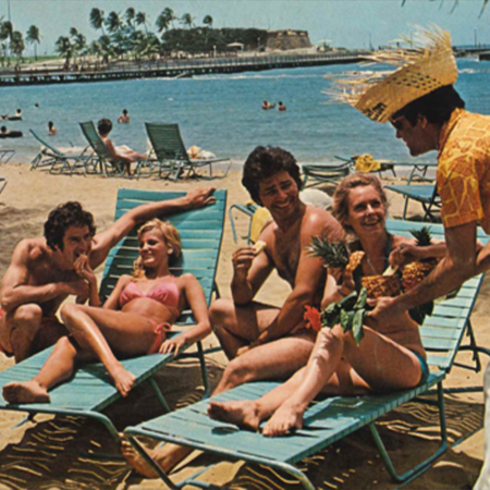 A butler serves piña coladas in halved pineapples at the Caribe Hilton in San Juan
