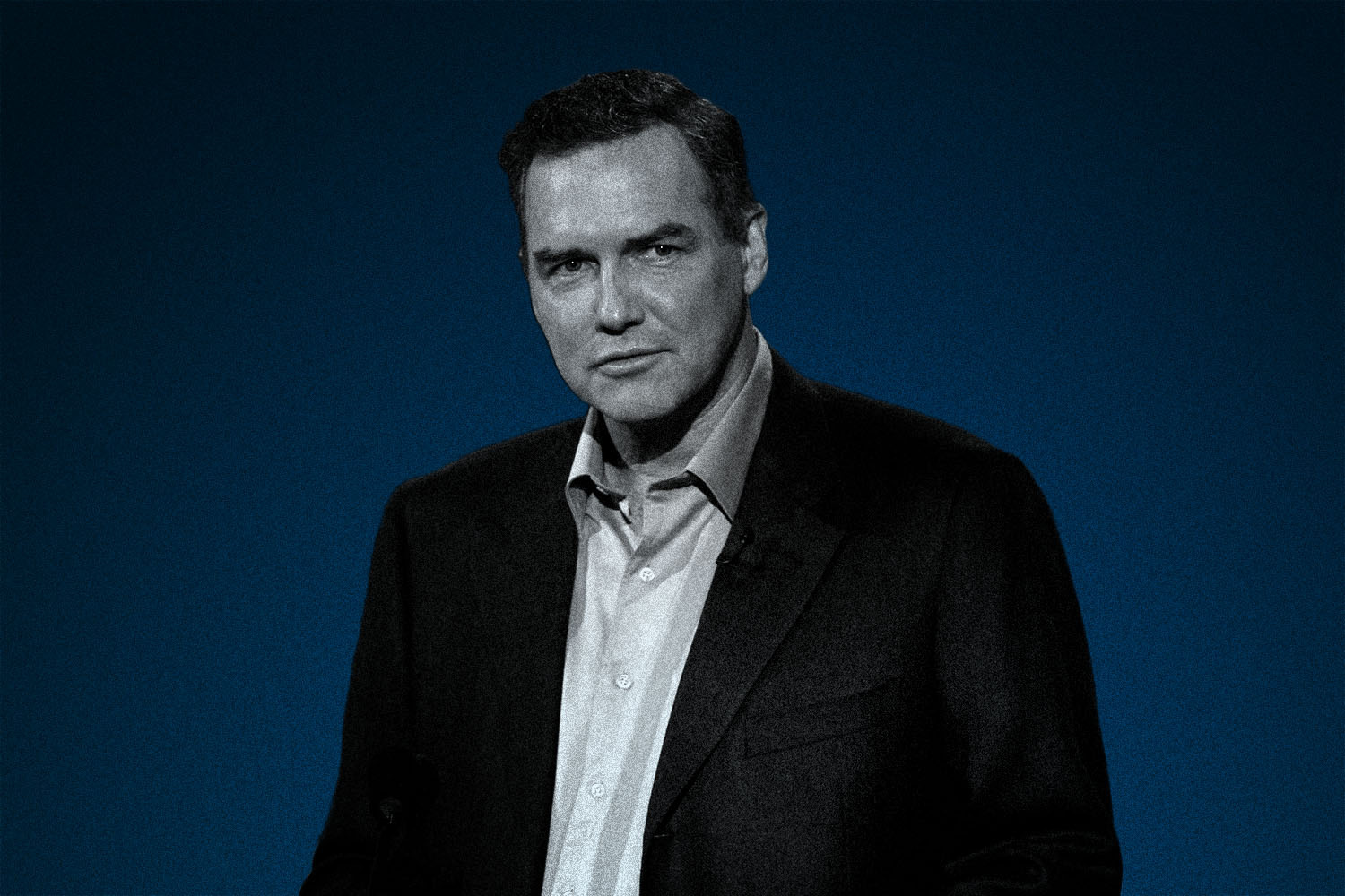 Comedian Norm MacDonald in a blazer and button-up shirt. MacDonald passed away this week at 61.