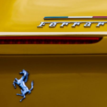 The words "Ferrari" and the luxury car brand's Prancing Horse logo on a yellow car