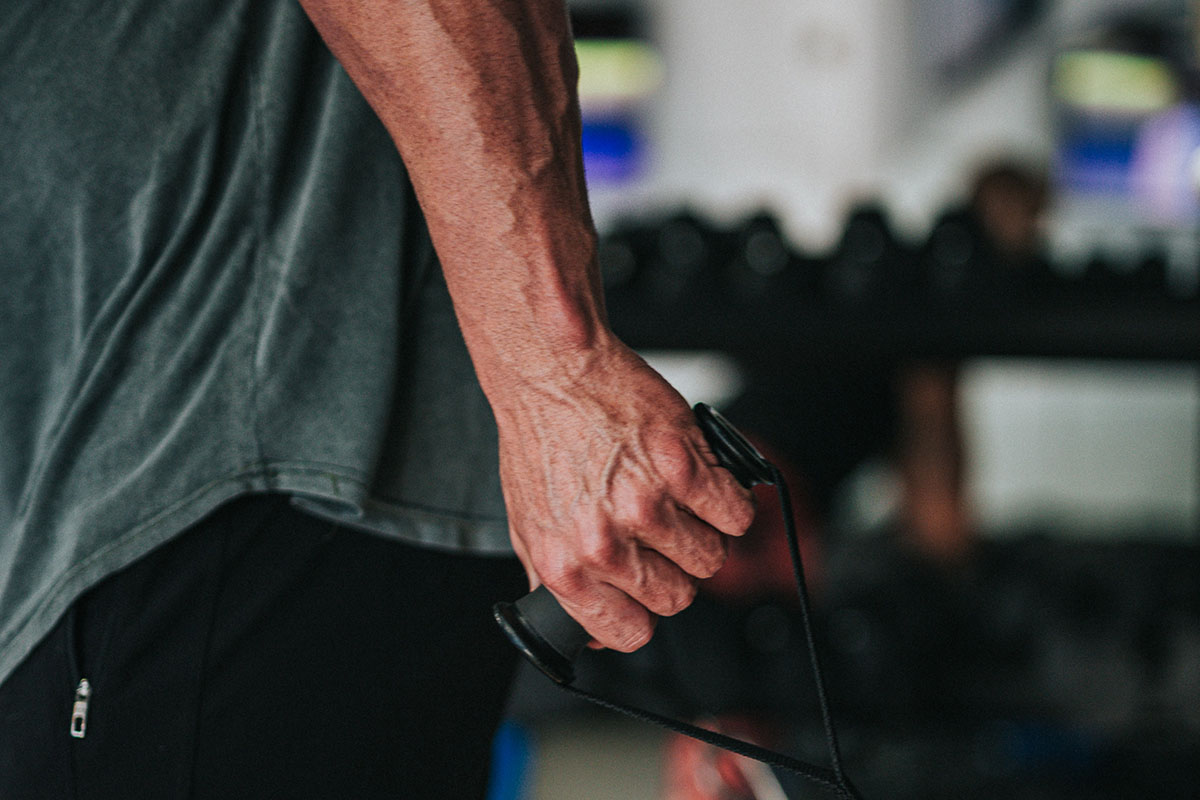 A man in the gym flexes his forearm muscles