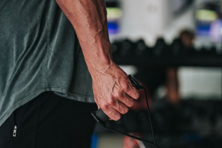 A man in the gym flexes his forearm muscles