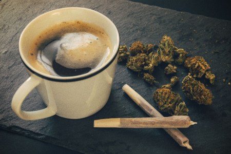 A cup of coffee, two joints and some loose cannabis. Weed and caffeine can work well together, according to some experts