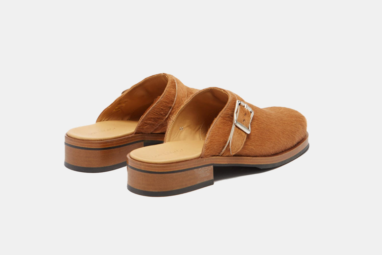 a pair of beige horse hair mules