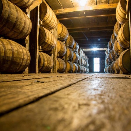 Bourbon barrels aging in a warehouse. Kentucky distilleries are getting hit hard by state taxes and international tariffs.