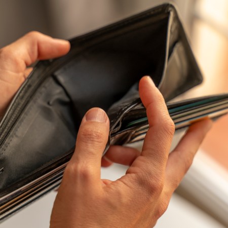 Man's hands opening up empty wallet