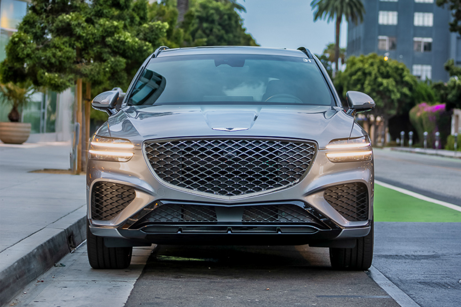 The front end of the Genesis GV70 SUV featuring a large grille and cheetah-scratch headlights