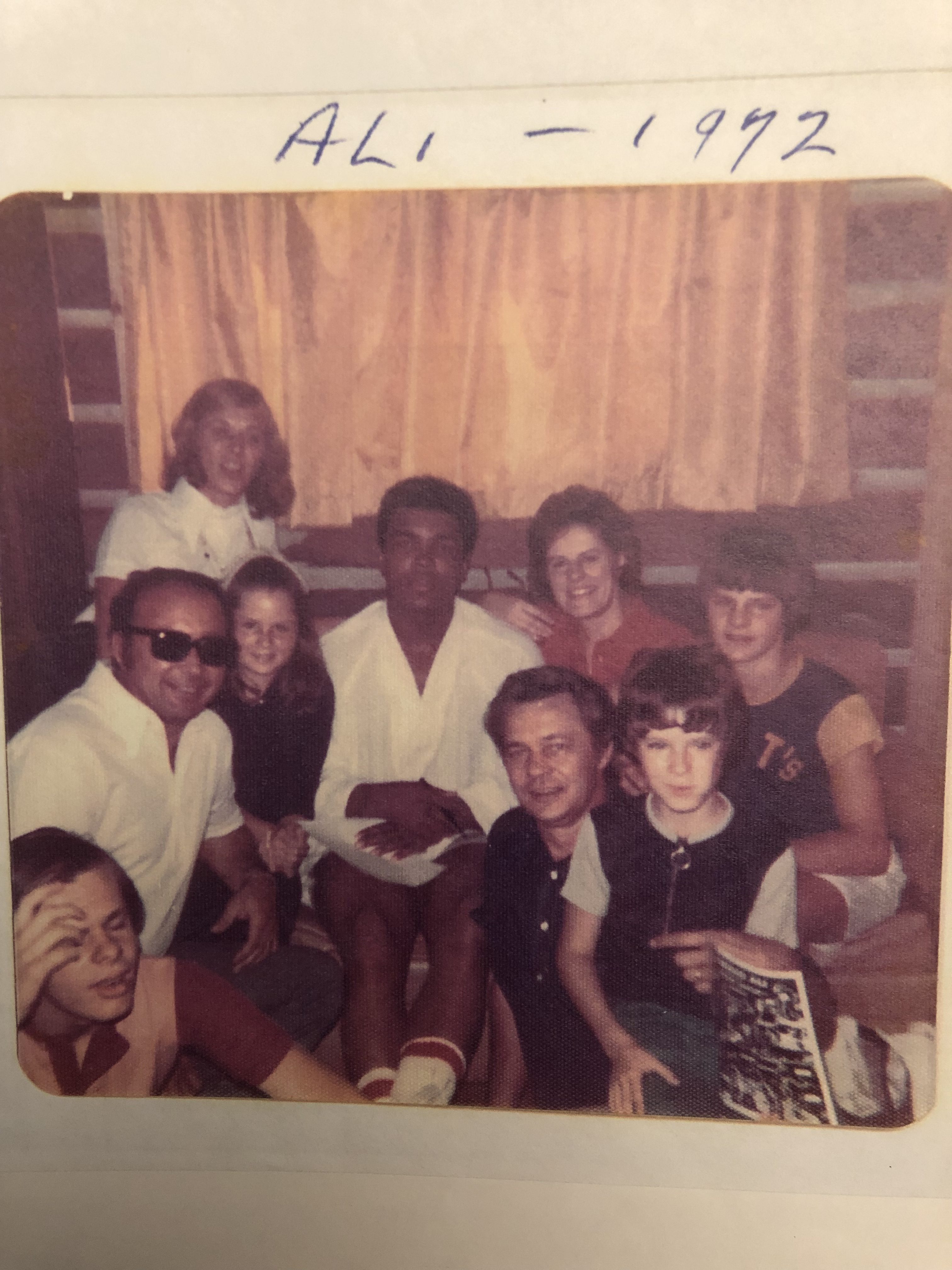 Muhammad Ali in a white robe, surrounded by the writer's family in 1072